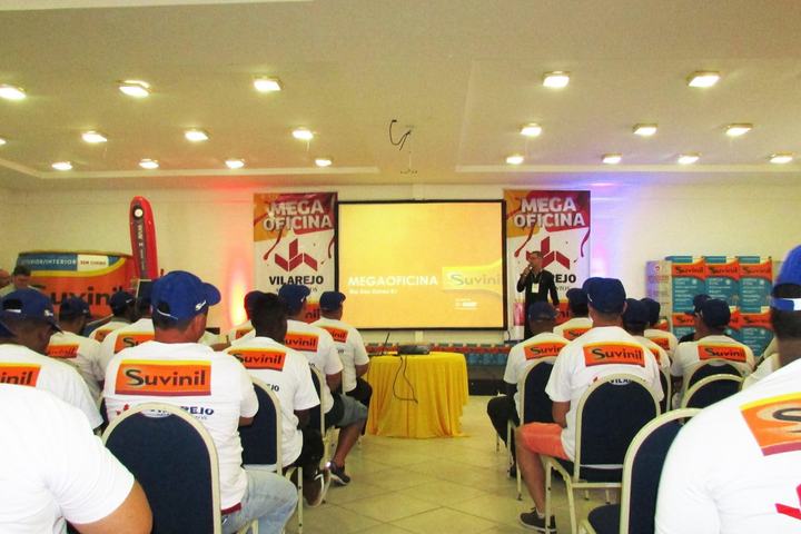 Full room of uniformed professional painters at the Mega Oficina Suvinil training